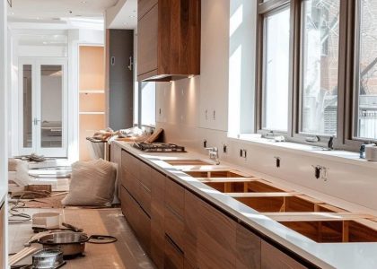 a kitchen with wood cabinets and a few windows